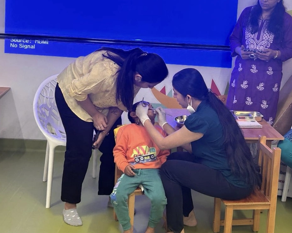 A dentist performing a dental checkup on a child at the outreach program